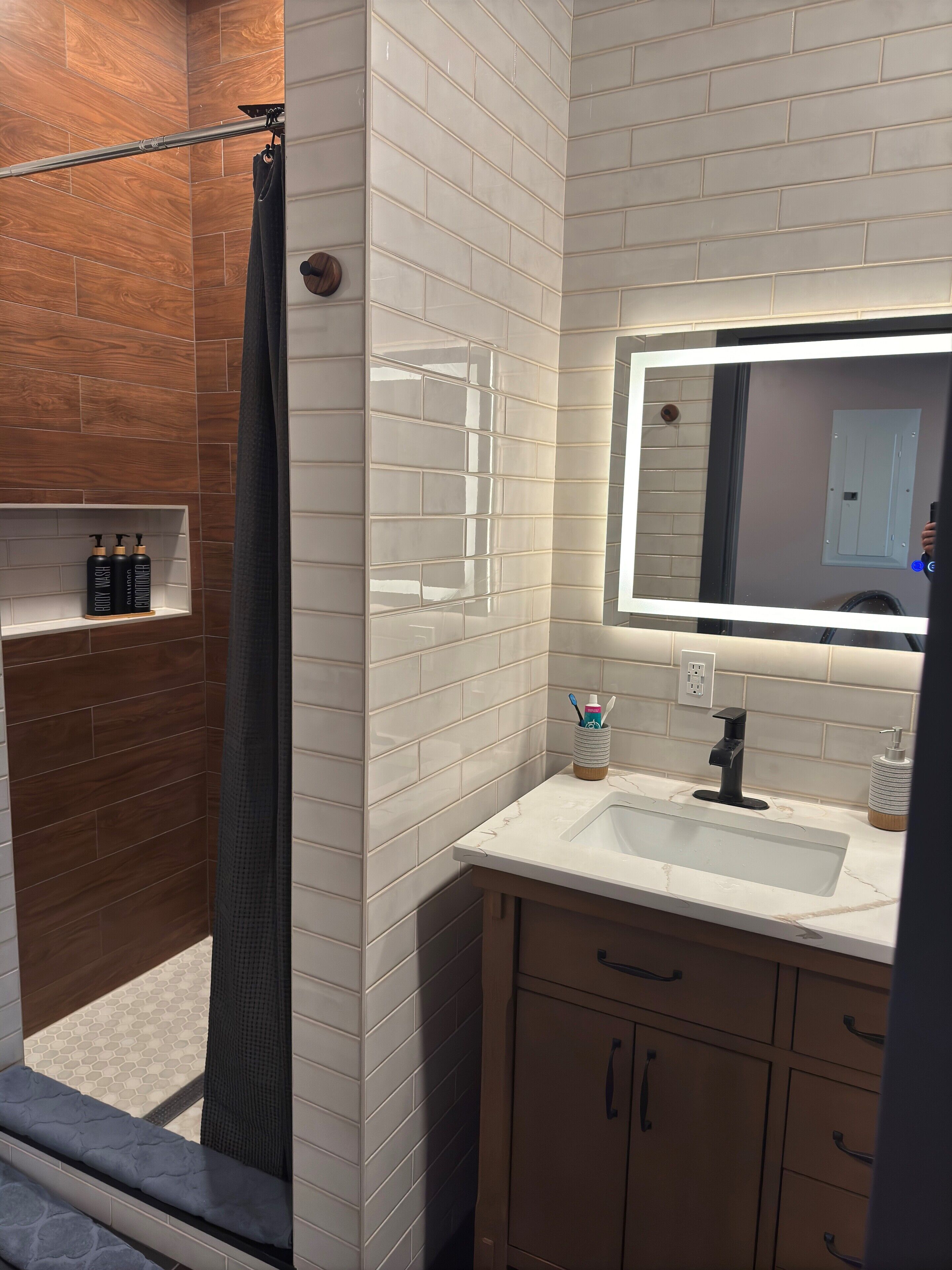 A modern bathroom with a shower, a vanity with a mirror, and a toilet.