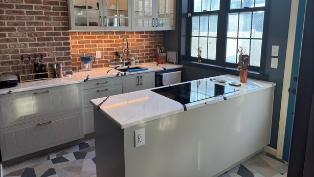 A modern kitchen with a central island, a brick wall, and a large window. - NEW! Modern Private Entrance, 2BD Apt. Minutes to NYC (Jersey City)