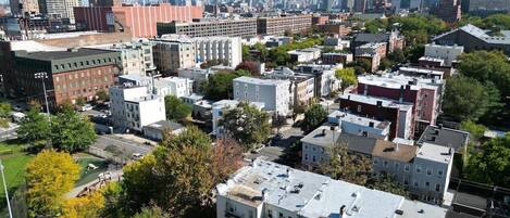 Una zona urbana densa con una mezcla de edificios residenciales y comerciales, incluyendo un edificio rojo destacado y varias estructuras altas al fondo.