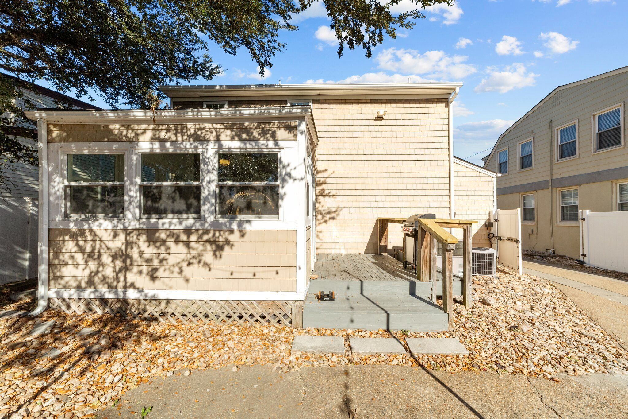 A single-story building with a front door, a small porch, and a covered outdoor seating area.