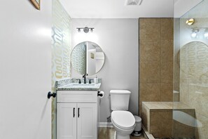 Un baño con inodoro, lavamanos y espejo.