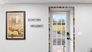 A door with a colorful tile border and a framed cityscape poster on the wall. - Casita Talavera (Nashville)
