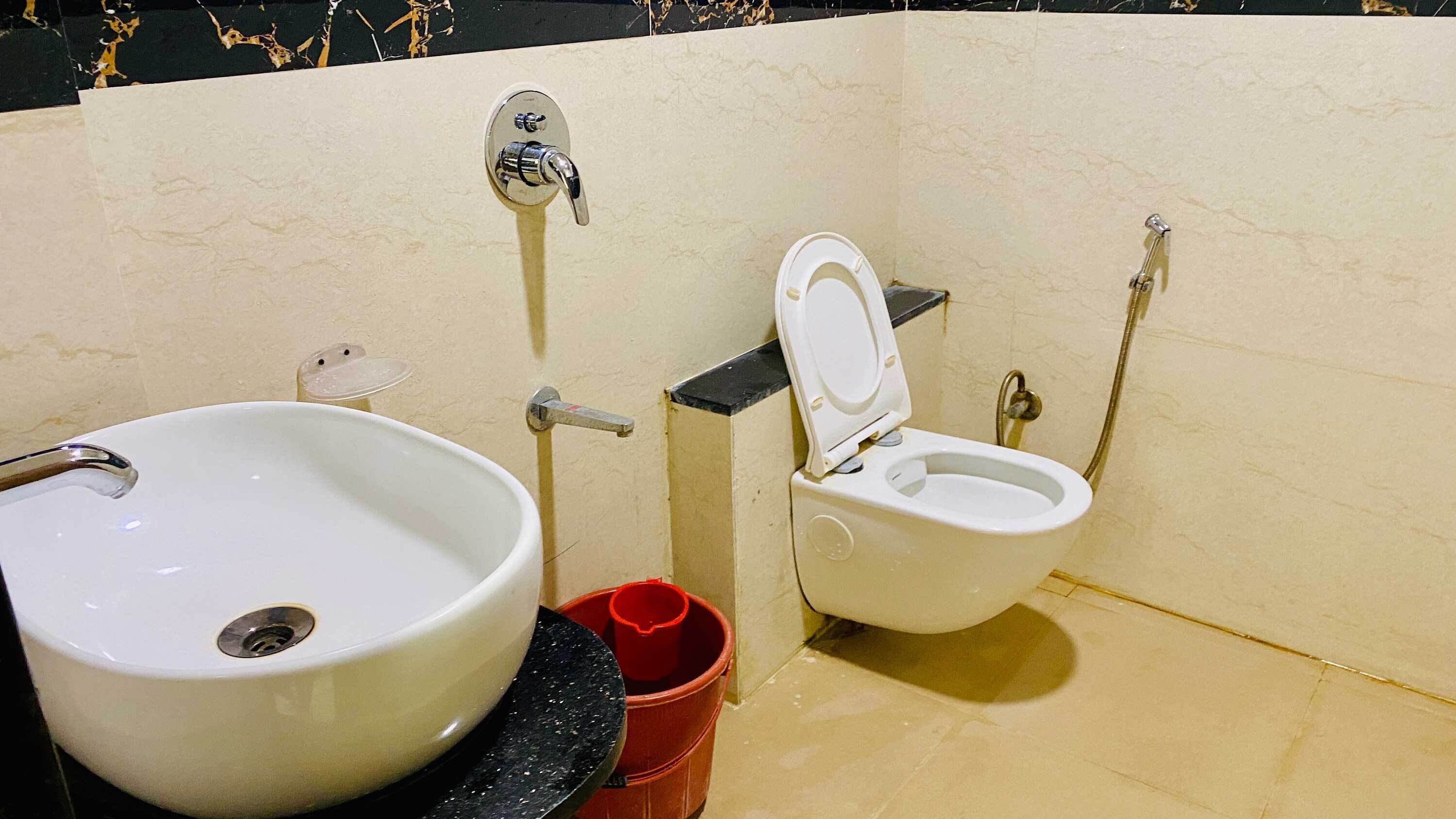 Un bany amb un rentamans gran de color blanc, un vàter i un bidet.