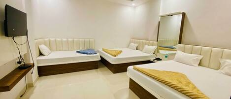 A hotel room with two beds, a flat-screen TV mounted on the wall, and a mirror.