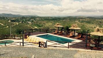 Relax by the resort's rectangular pool surrounded by lounge chairs and a shaded area.