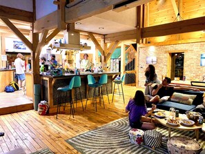 Un interior acogedor con una zona de bar, asientos y una cocina.