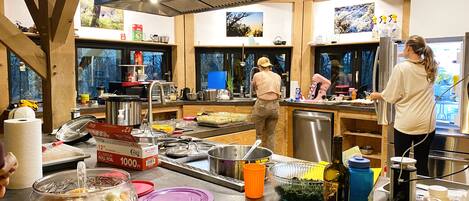 Una cocina con vigas de madera, electrodomésticos de acero inoxidable y un ventanal grande.