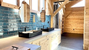 A modern bathroom with a wooden ceiling, a large mirror, and a blue-tiled backsplash. - Arete Hostel (Summersville)