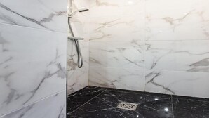 A bathroom with white marble tiles and a black marble floor. - Tranquille studio - 4P- Place de la Bastille (Paris)