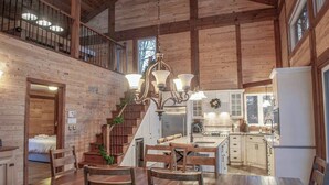 Une cuisine spacieuse avec des meubles en bois, un îlot central et un lustre.