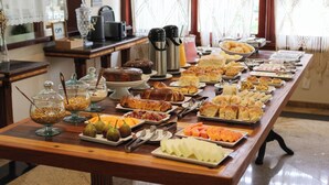 A buffet table with various food items and condiments. - Pousada Costa Rielli (Águas de Lindóia)