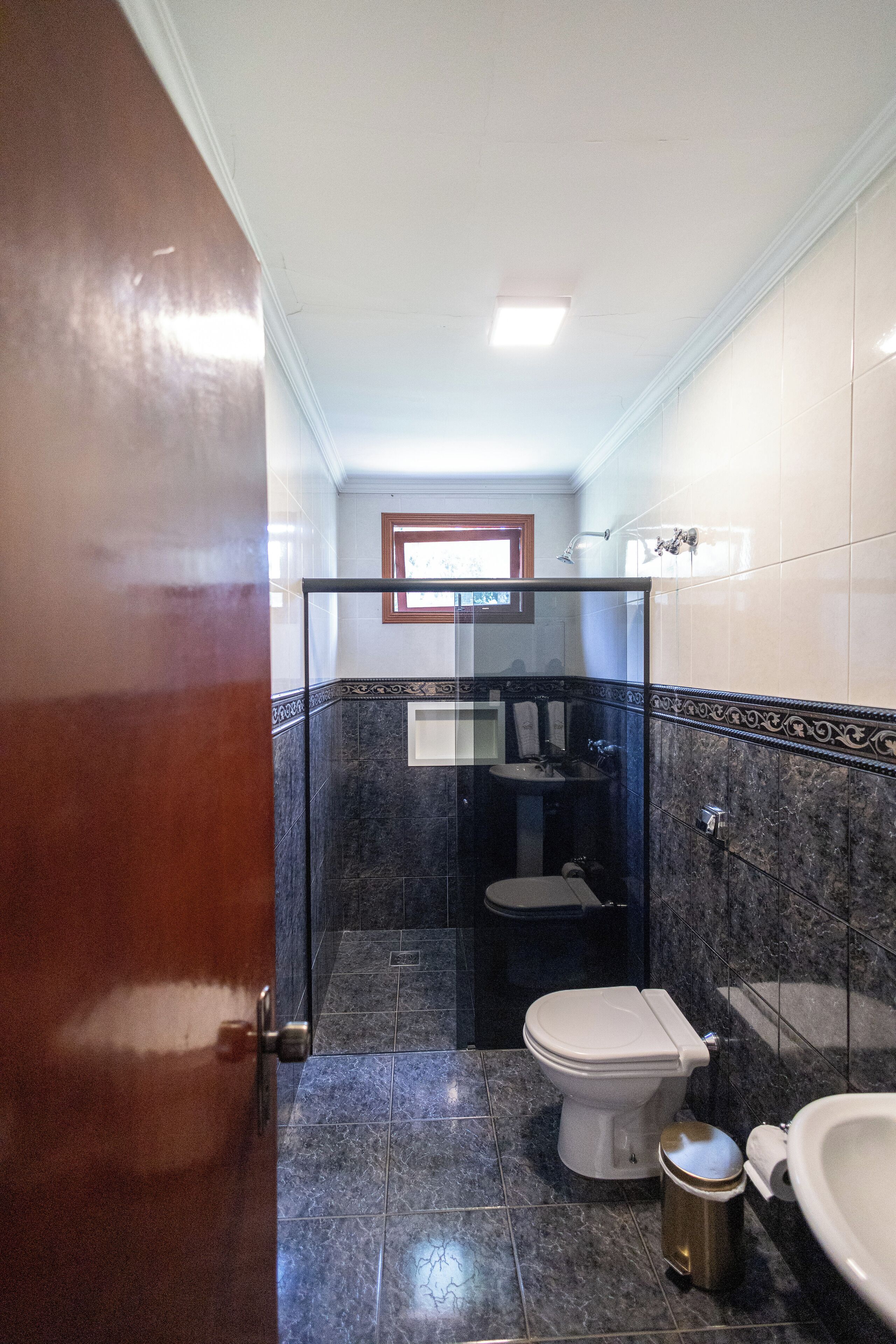 A bathroom with a toilet, sink, and shower.