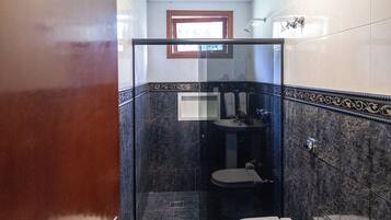 A bathroom with a toilet, sink, and shower.