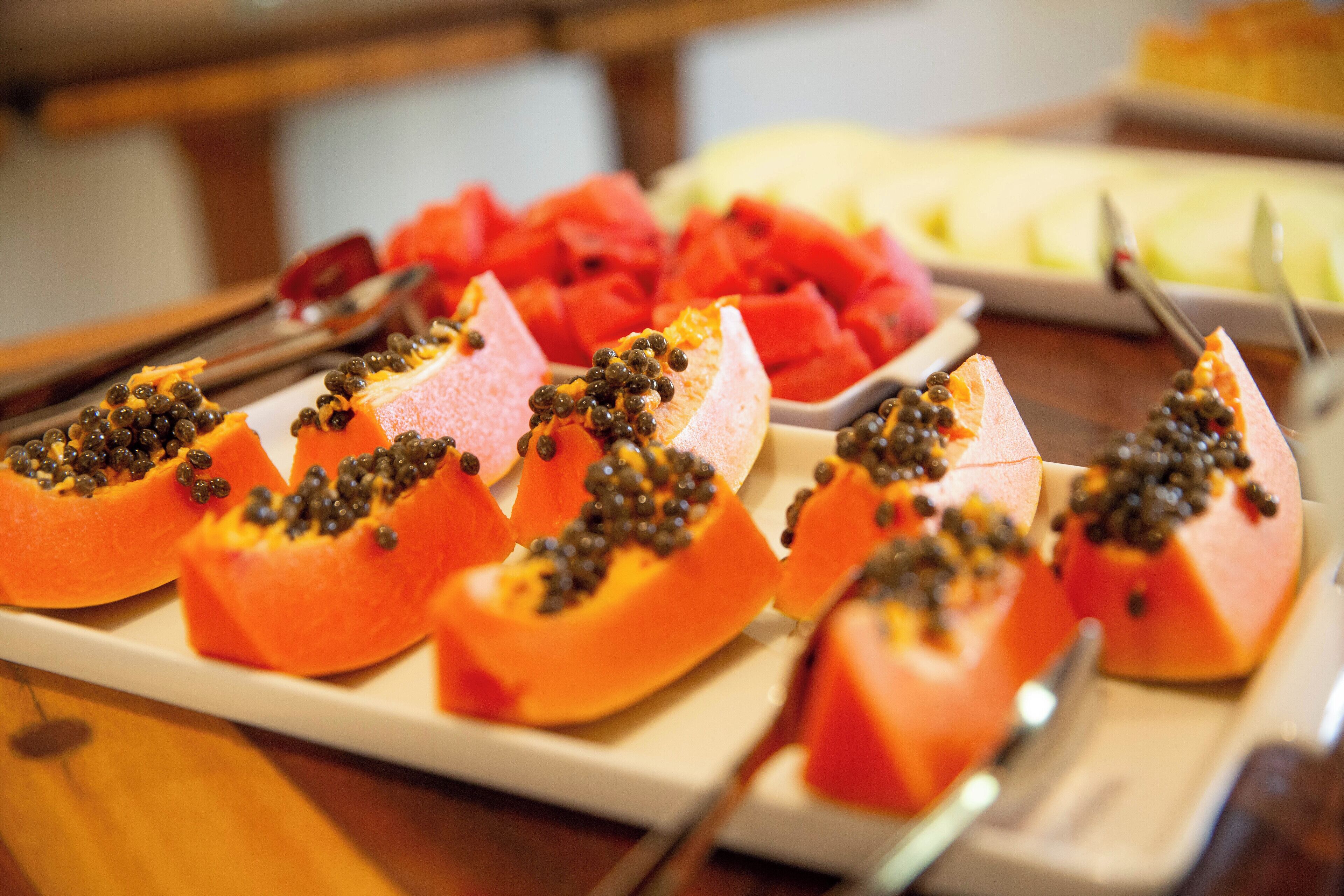 A buffet with various fruits including papaya and watermelon.