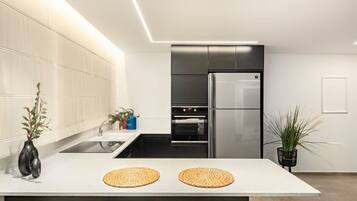 A modern kitchen with a central island, stainless steel appliances, and minimalist decor.