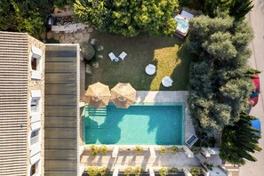 Eine Vogelperspektive eines Anwesens mit Schwimmbad, Liegestühlen und einer Terrassenanlage.