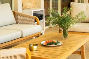 A modern living room with a sofa, a coffee table, and a potted plant.