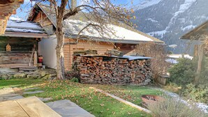A rustic cabin with a stone foundation, a wooden deck, and a stone table. - Perfect Lodge 10 mns from Verbier - 4 Valleys . Sw (Sarreyer)