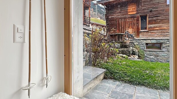 A room with a bench, wooden skis, a stone wall, and a view of a rustic building. - Perfect Lodge 10 mns from Verbier - 4 Valleys . Sw (Sarreyer)