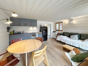 A compact living space with a kitchen, dining area, and a sofa.