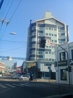A multi-story building with a modern architectural design, featuring balconies and large windows.