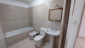 Une salle de bain équipée d’une baignoire, d’un bidet, de toilettes et d’un lavabo.