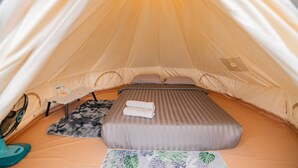 A tent with a bed, a small table, and a pet bed. - Mankhao Homestay (Mae Rim)