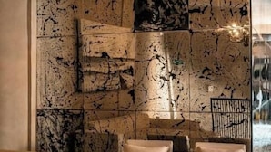 Un vestíbulo con suelo estampado, una araña y una pared con arte abstracto.