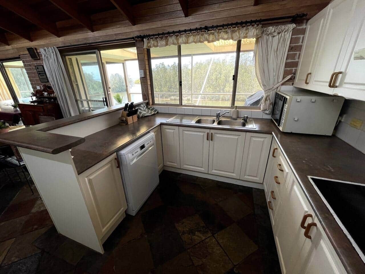 A kitchen with a dishwasher, a sink, and cabinets.