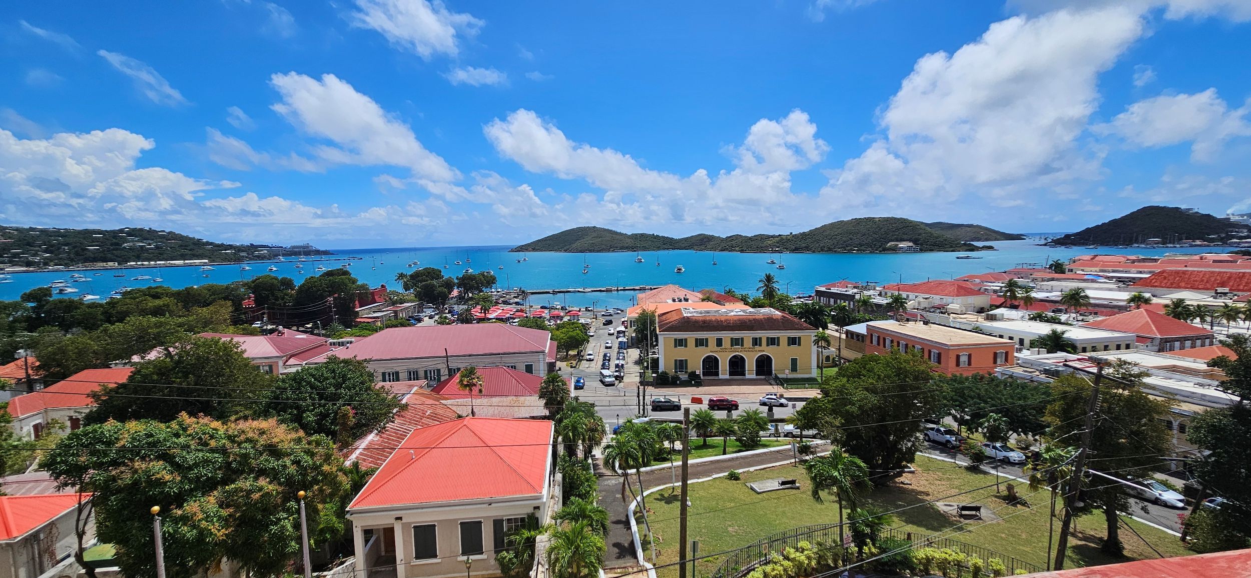 A coastal town with buildings, a marina, and clear blue skies.
