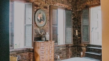A bedroom with a bed, dresser, and a ceiling fan.