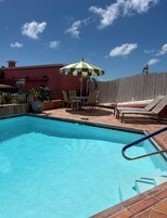 Una piscina al aire libre, sombrillas, tumbonas