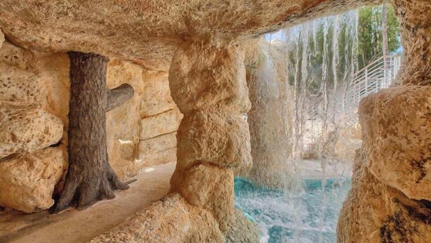 A natural rock formation with a water feature, including a waterfall and a viewing platform. - Sunrise Retreat: Ocean & Pool Views, Gym, PB Courts, Game Room, Marina and more (Key Largo)