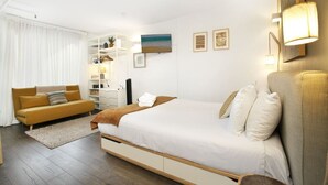 A hotel room with a bed, a sofa, a desk, and a TV. - Stylish Bondi Studio Minutes From Bondi Beach (Bondi)