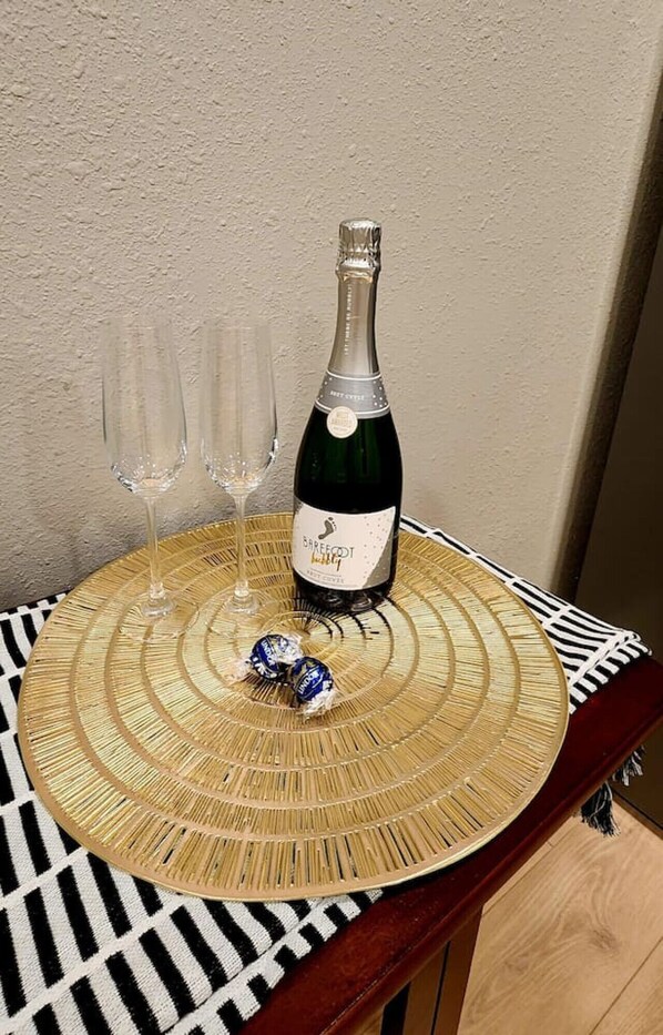 A bottle of Barefoot wine on a woven placemat with two glasses. - Mahase Guest House at The Refuge (Osceola)