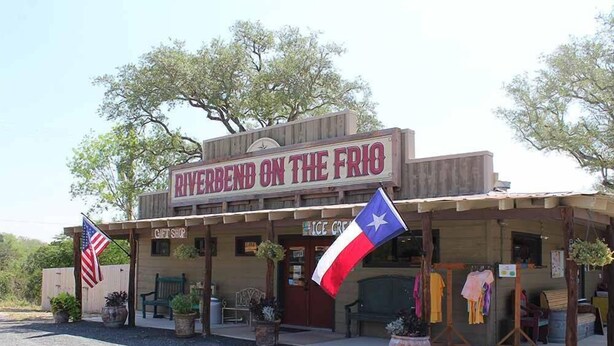 A rustic building named 'Riverbend on the Rio' with a gift shop and ice cream sign.