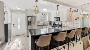 A modern kitchen with a large island, stainless steel appliances, and pendant lighting. - Steps to Beach - 2 MBR-2.5 Bath, Sleeps 6, Gulf Highlands Beach Resort Townhome (Panama City Beach)