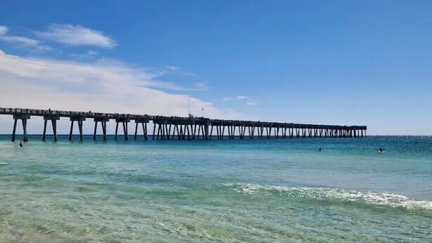 A pier extending into clear turquoise water with a sandy beach in the foreground. - Steps to Beach - 2 MBR-2.5 Bath, Sleeps 6, Gulf Highlands Beach Resort Townhome (Panama City Beach)