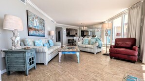 A spacious living room with striped sofas, a red armchair, and a coffee table.