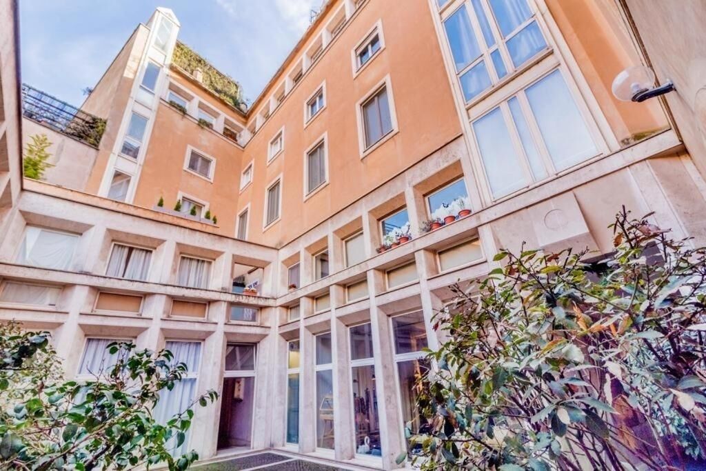 A multi-story building with a central courtyard, large windows, and balconies.