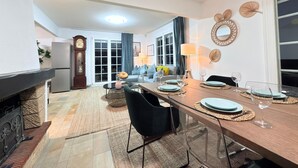 A modern kitchen with a dining area, a fireplace, and a large window with curtains. - Spacious 4 bedrooms House (Strassen)