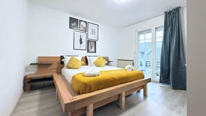 A modern bedroom with a wooden bed, a bench, and a view of the outside. - Spacious 4 bedrooms House (Strassen)