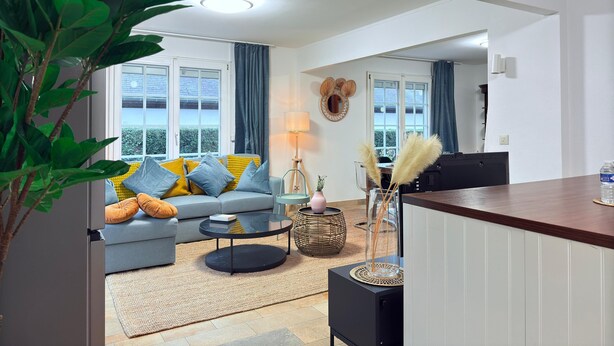 A modern living room with a sofa, coffee table, and decorative items. - Spacious 4 bedrooms House (Strassen)