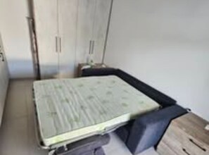 Tabla de planchar con plancha, internet y ropa de cama