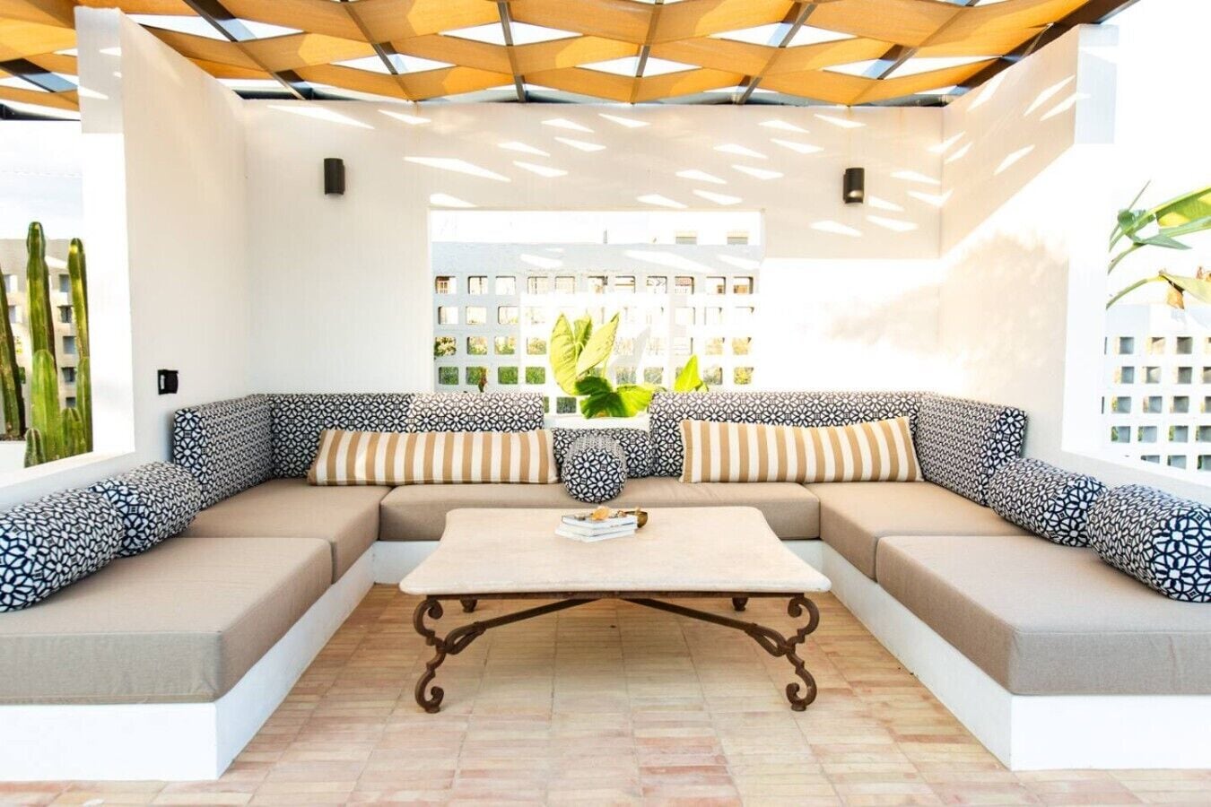 A modern living room with a sectional sofa, a coffee table, and a patterned wall.