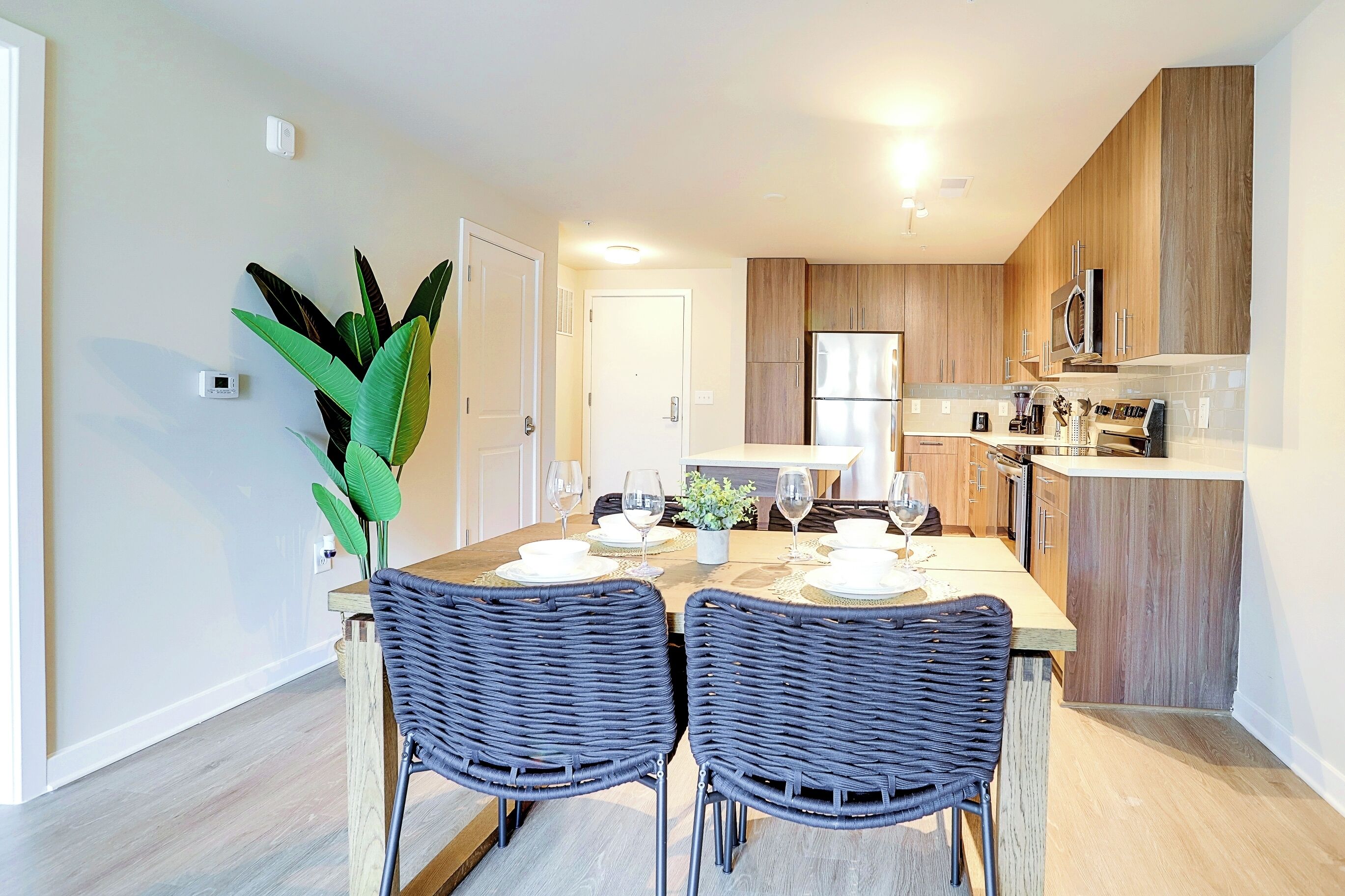 A modern kitchen with wooden cabinets, a built-in microwave, and a stainless steel refrigerator.