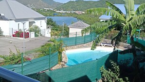 A pool area with a view of a mountain and a body of water in the background. - Master suite + breakfast (saint martin)