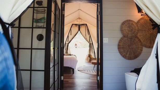 A cozy room with a bed, a hanging chair, and a large window. - The Chetopa, Luxury Safari Tent (Cadiz)