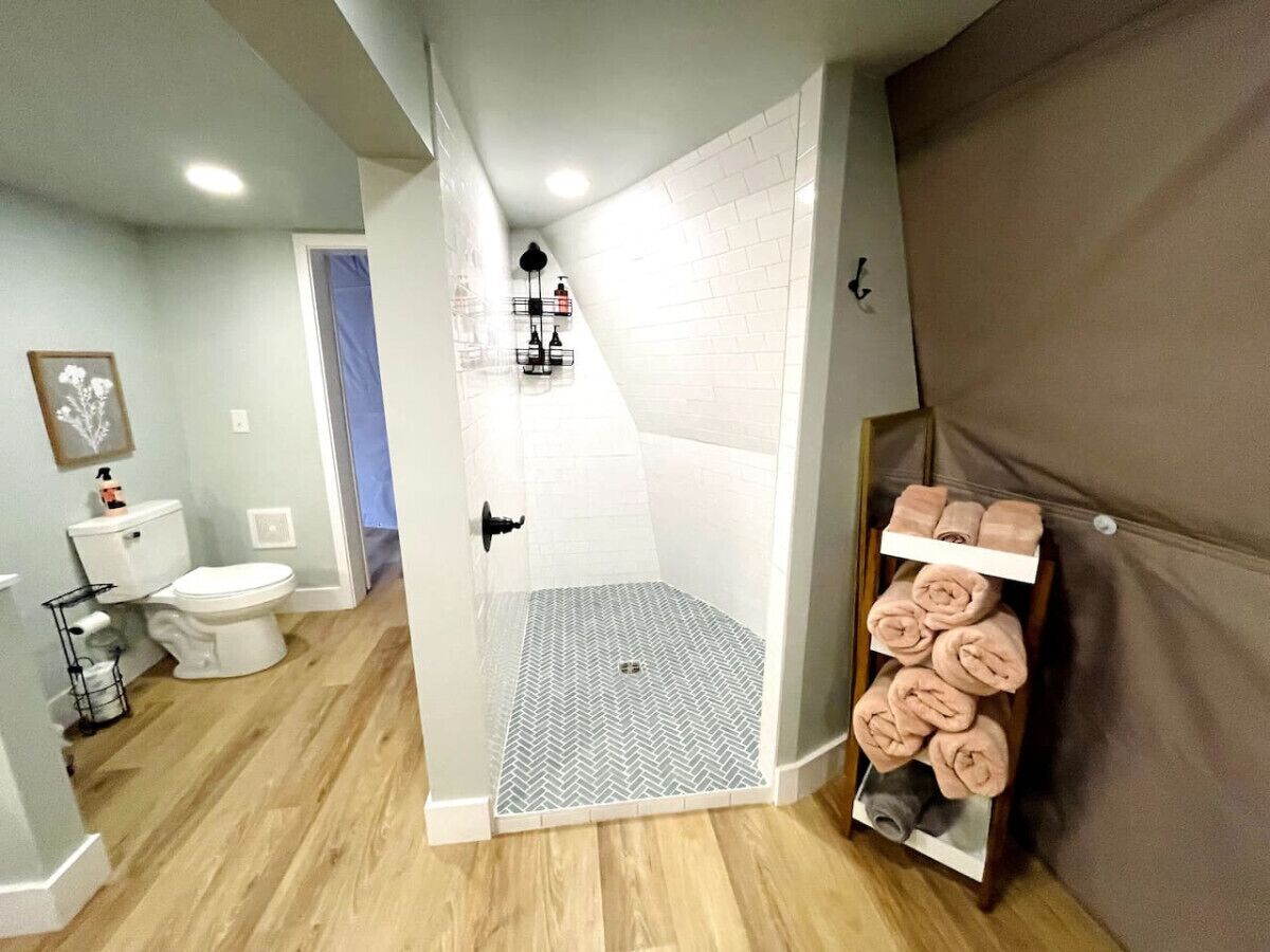 Une salle de bain équipée d’une douche, de toilettes et d’un porte-serviettes.