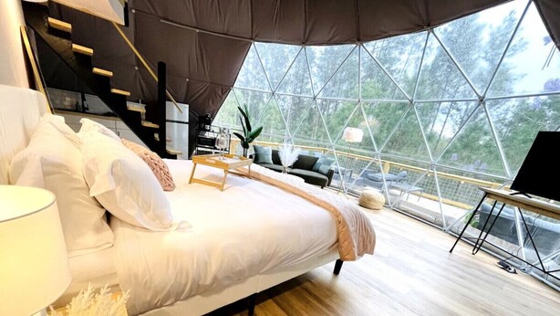 Une chambre moderne avec un grand lit, un bureau et un escalier.